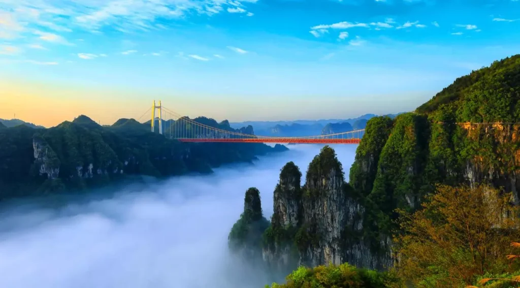 Aizhai Wonders Tourist Area view of Aizhai Bridge above cloud sea, cliffs and mountain peaks.