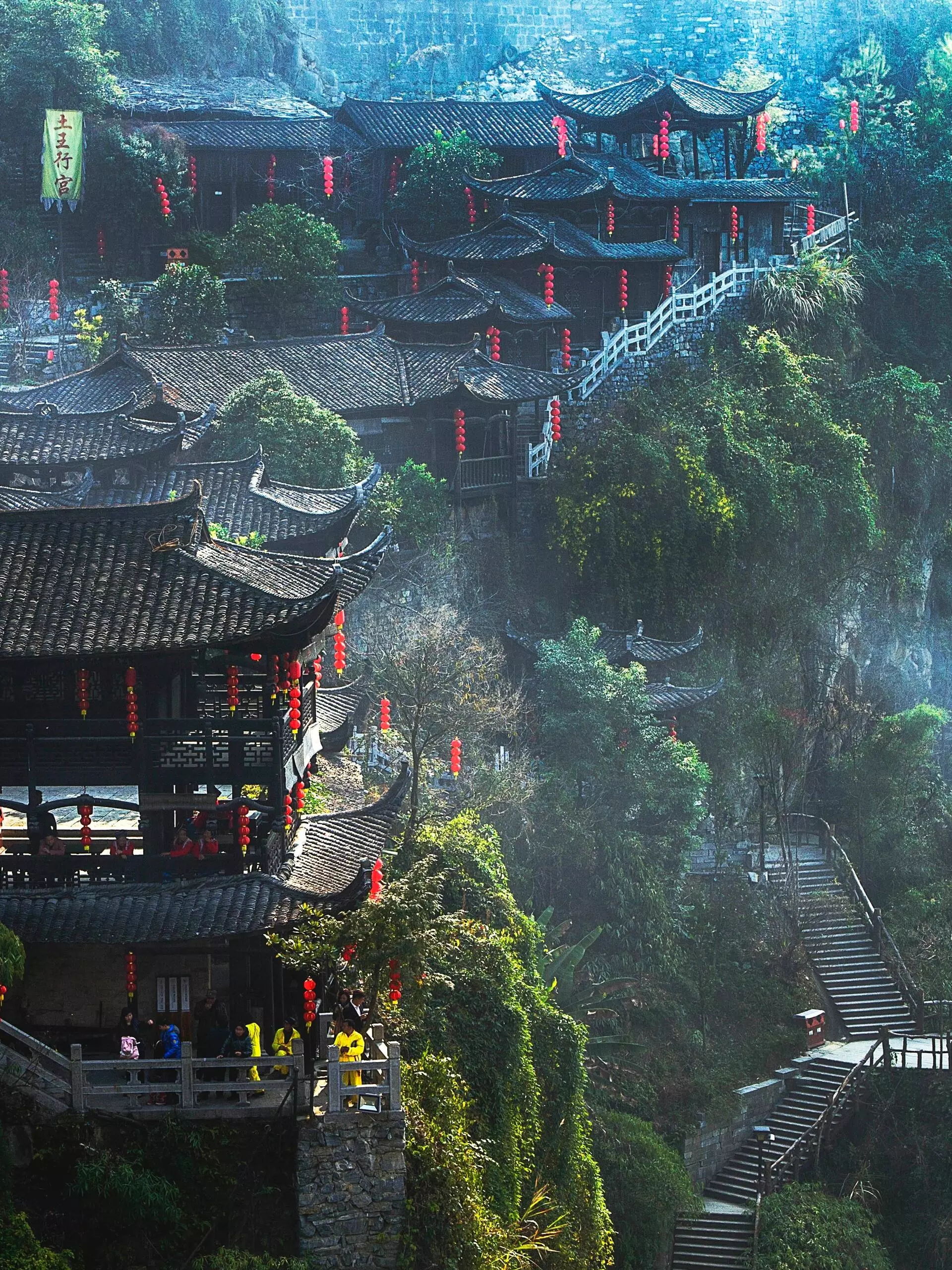 Furong Ancient Town cliffside wooden houses with lanterns and mountain pathways