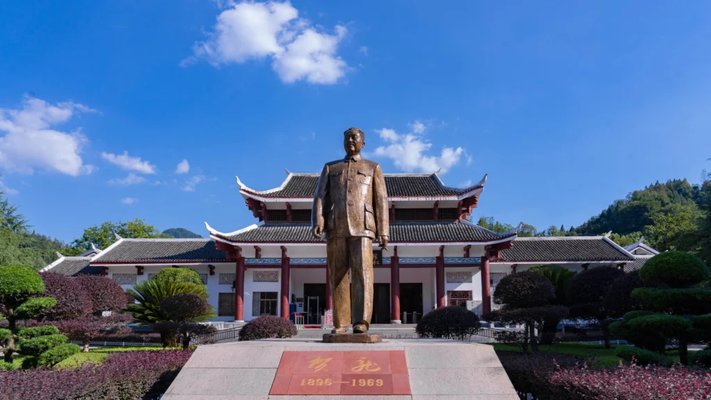 Helong Former Residence memorial hall with central statue and landscaped garden