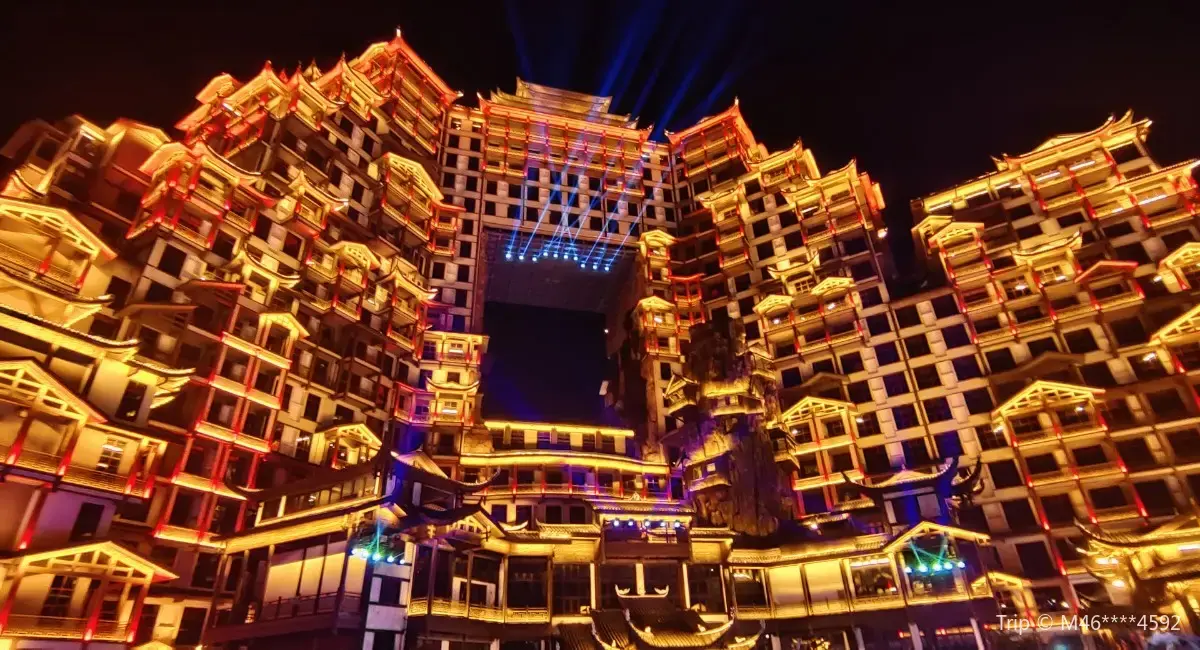 Zhangjiajie 72 Wonder Tower light show time with golden night lights and illuminated Tujia-style architecture