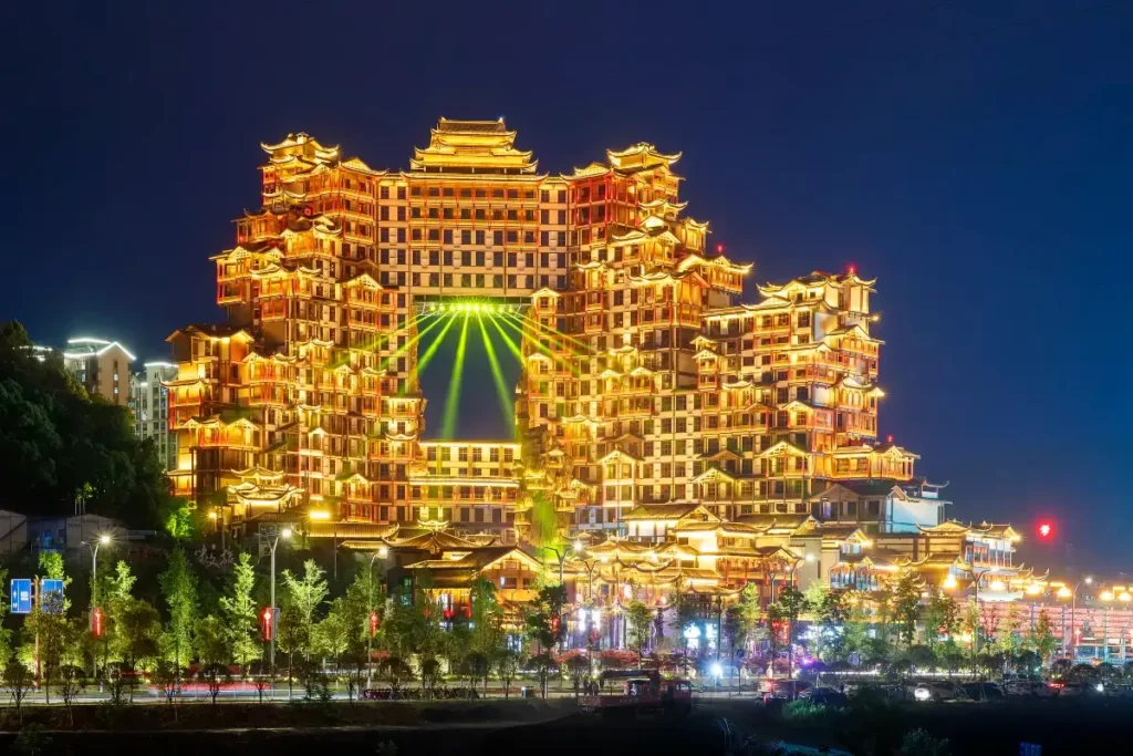 Zhangjiajie 72 Wonder Tower light show time seen from the city with bright lights and evening traffic