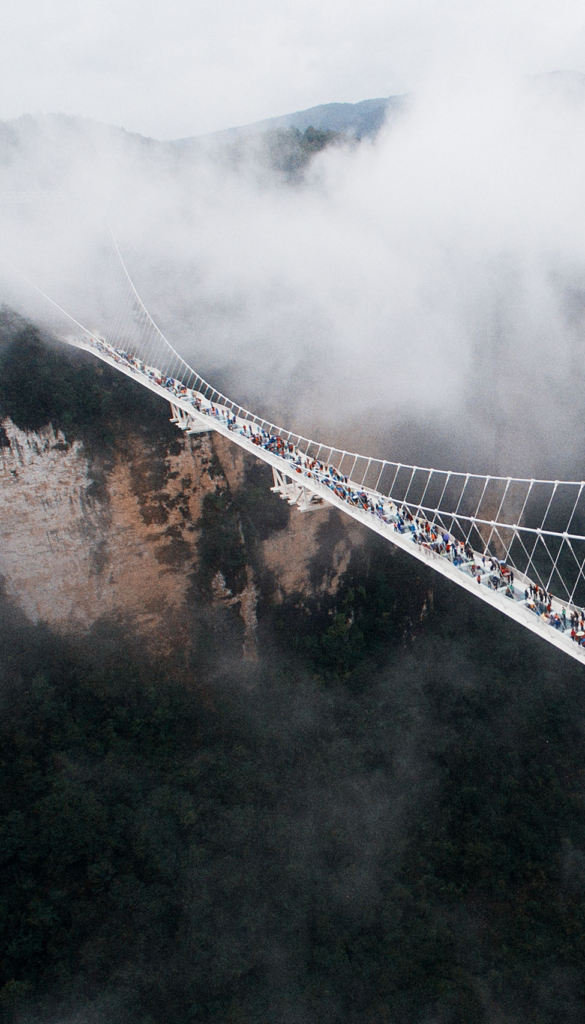 zhangjiajie grand canyon glass bridge surrounded by mist and mountain cliffs