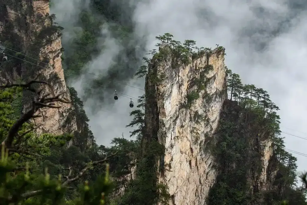 tianzi mountain cable cars passing between cloudy sandstone cliffs in Zhangjiajie