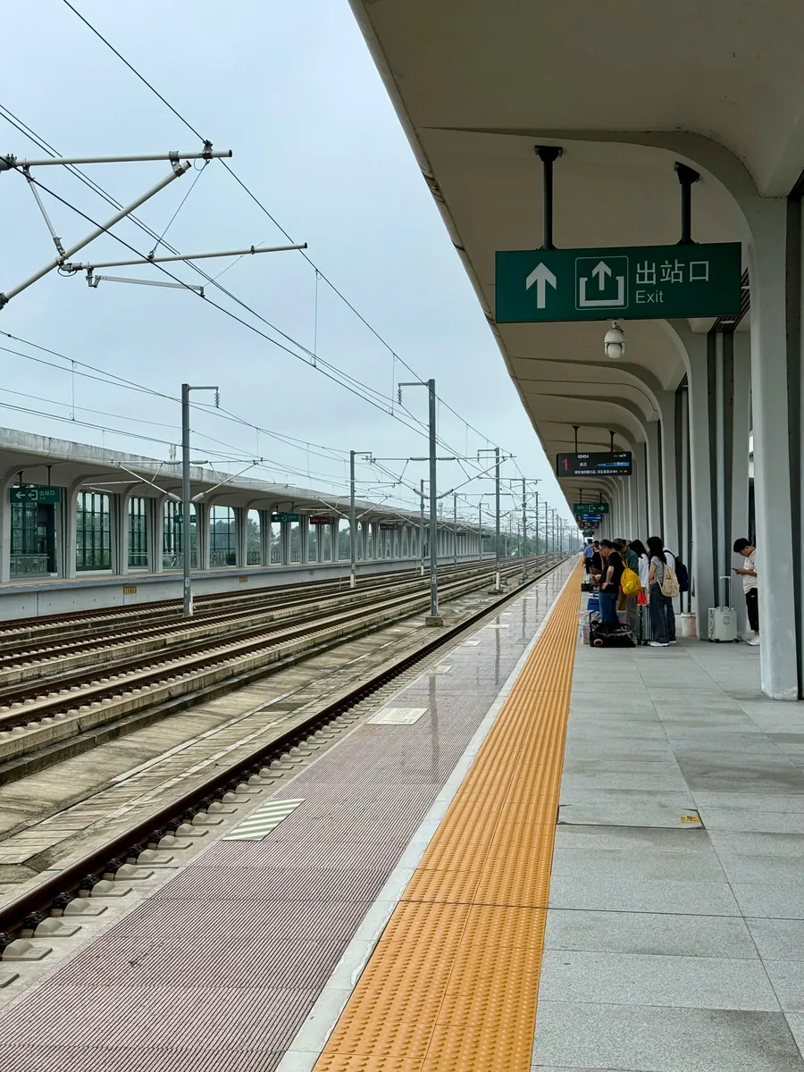 zhangjiajie travel guide passengers with luggage on a Chinese train platform for arrival planning