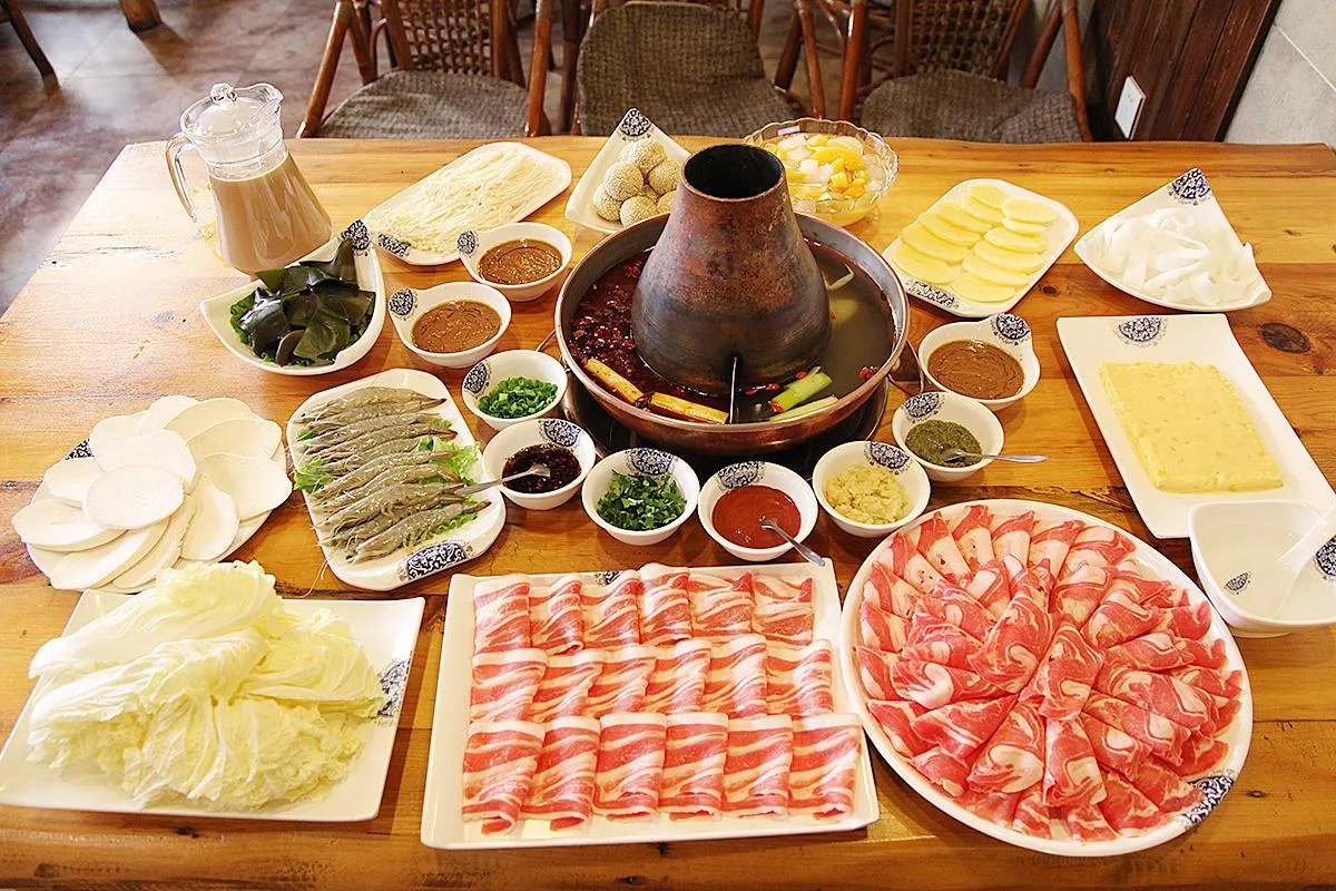 Halal hotpot table with sliced beef, lamb and fresh vegetables in Chongqing