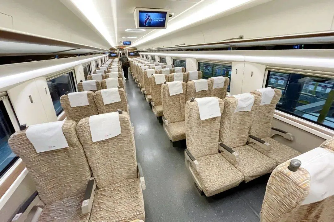 Second-class carriage of a Chinese high-speed train with 3+2 seating and overhead luggage racks