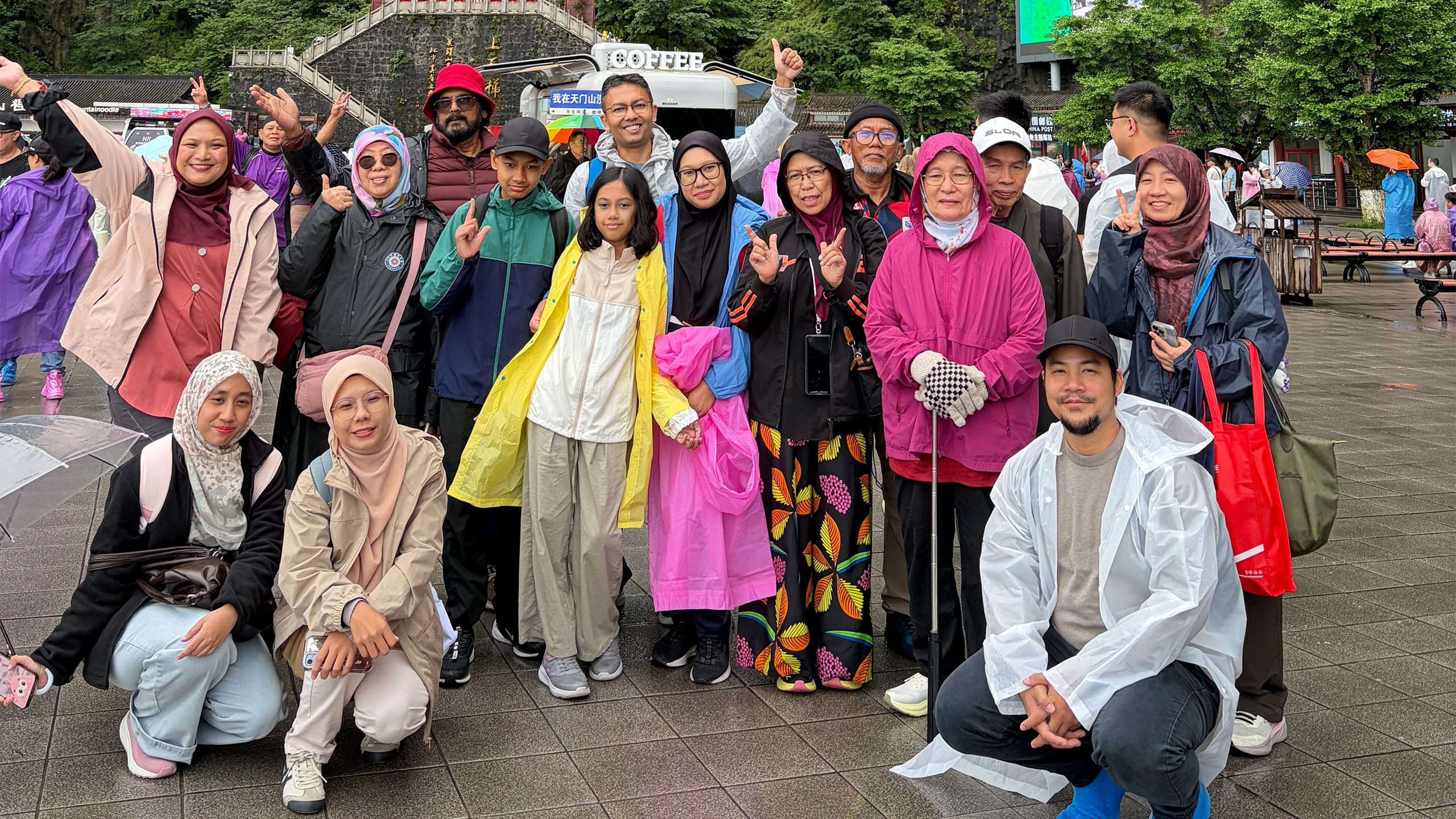 Muslim travel group posing beneath a natural mountain arch in Zhangjiajie