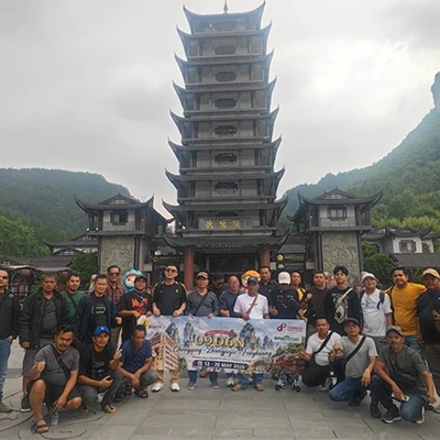 Ahmad and a travel group posing at a scenic site in China