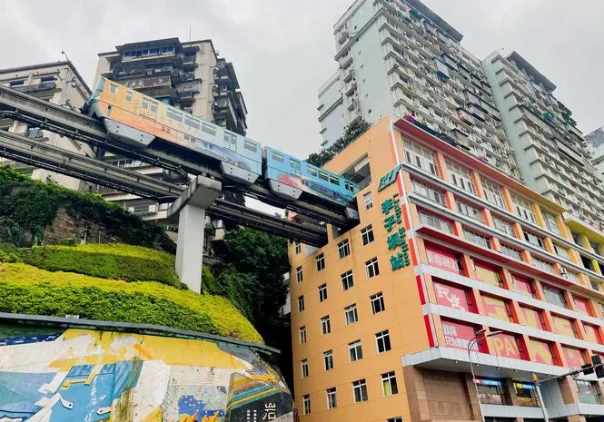 Monorail train passing through a residential building at Liziba station, Chongqing