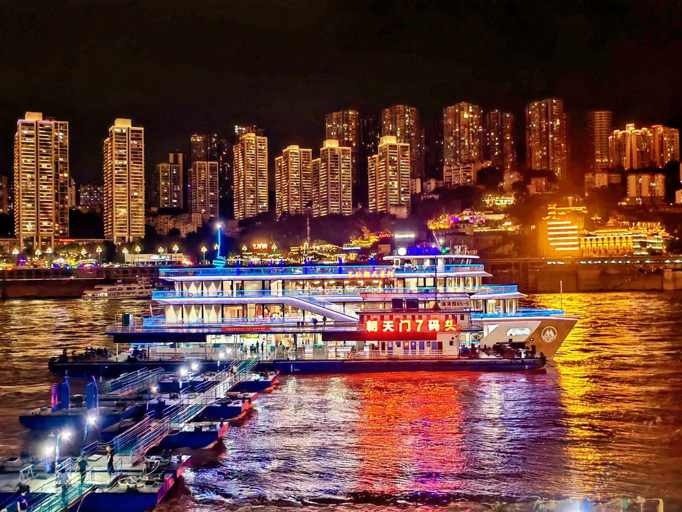 Two Rivers night cruise boats at Chaotianmen pier with the Chongqing skyline behind