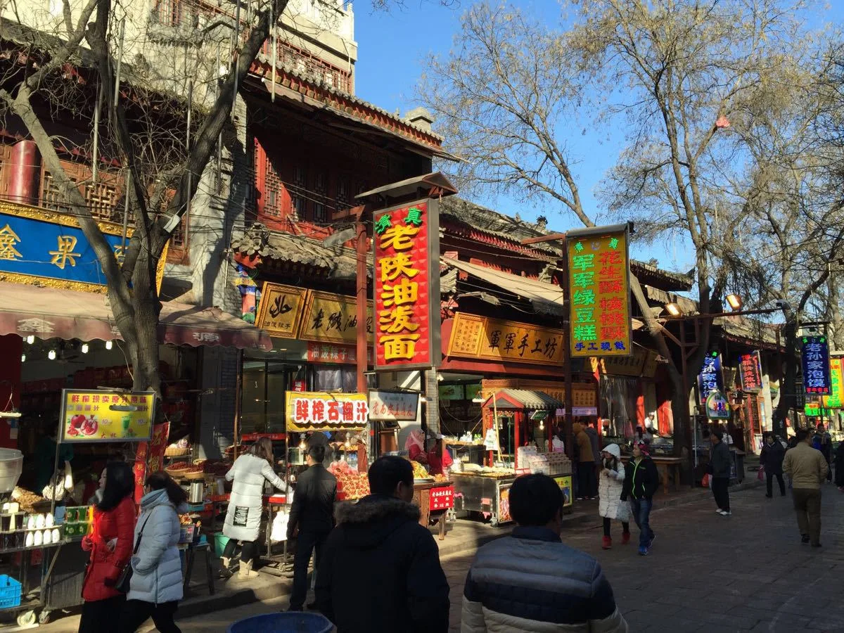 Food stalls and halal snack shops along a busy street in Xi'an's Muslim Quarter