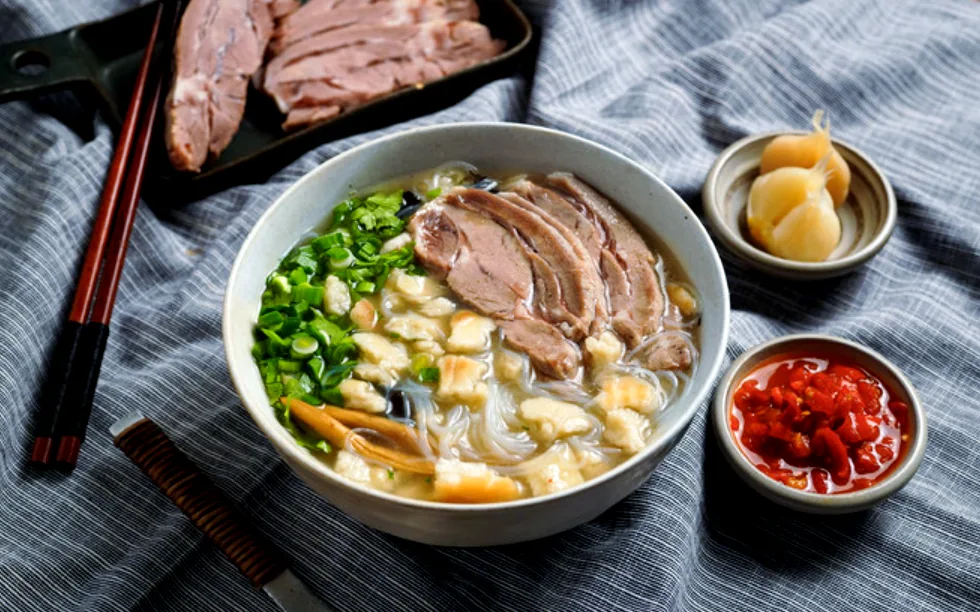 Bowl of yangrou paomo with lamb, torn flatbread and vermicelli, Xi'an's signature halal dish