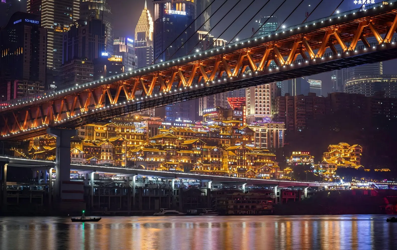 Chongqing skyline at night with Hongyadong stilted houses lit up under Qiansimen Bridge