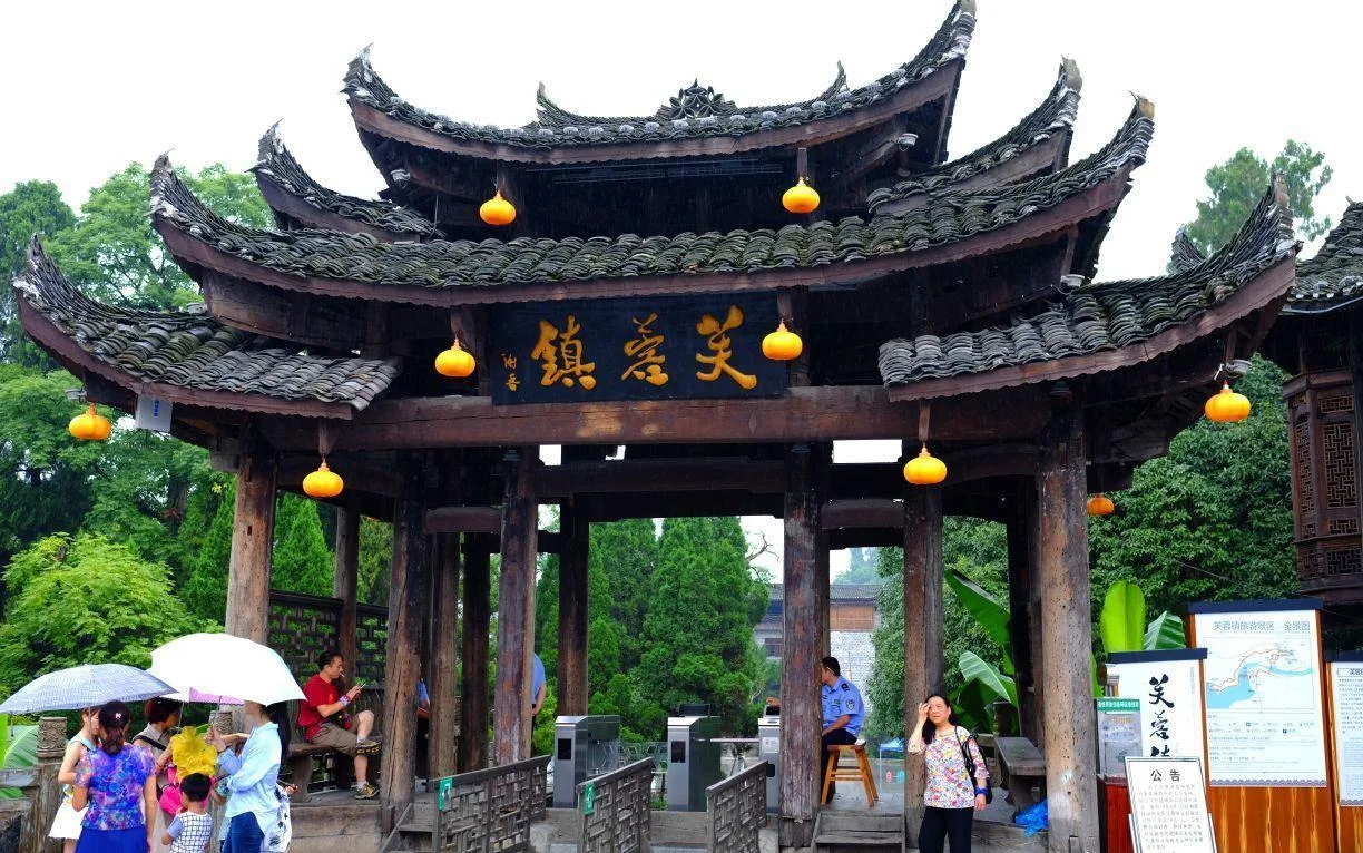 Entrance gate of Furong Ancient Town with ticket turnstiles under the wooden archway