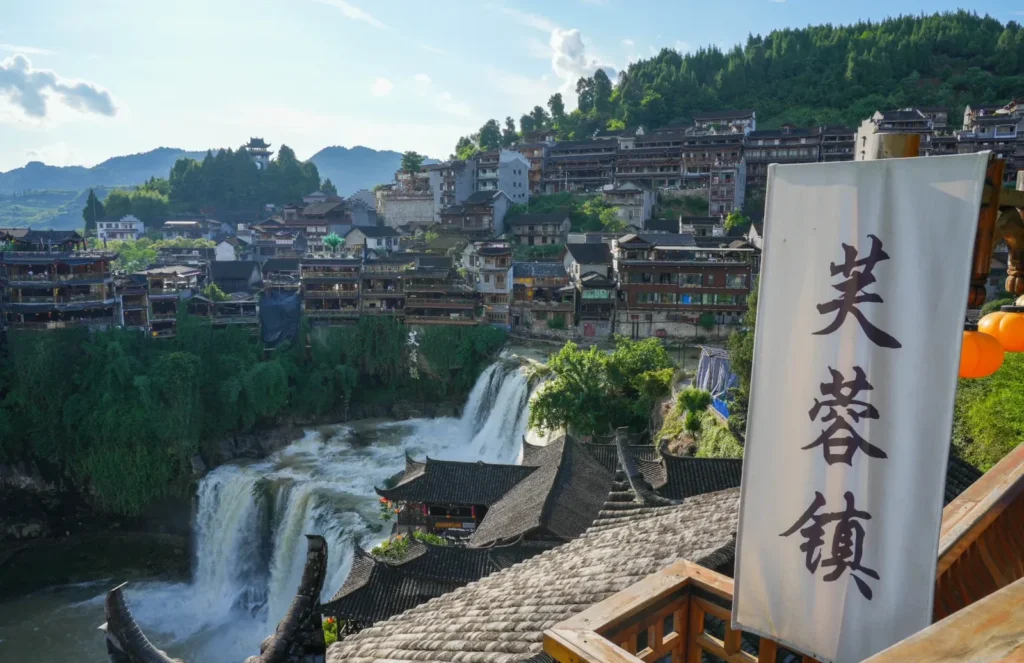 Furong Ancient Town waterfall and stilted houses on the cliff in daylight