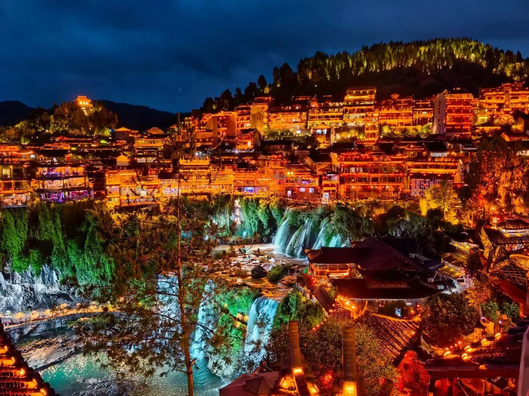 Furong Ancient Town waterfall and stilted houses illuminated at night