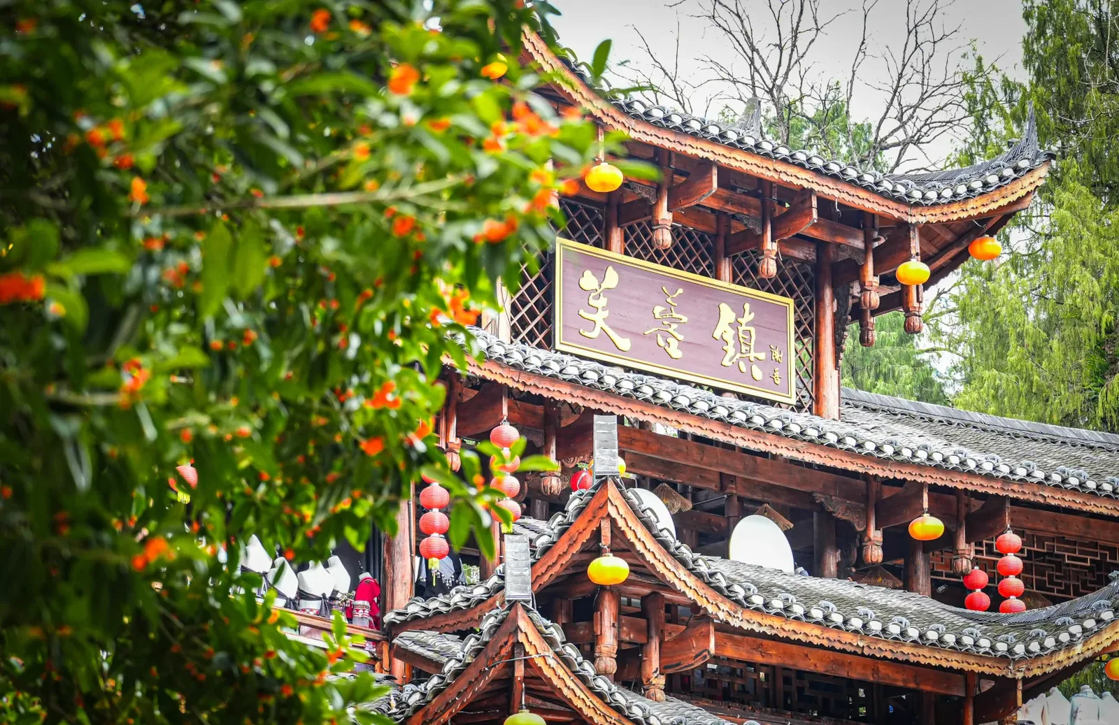 Wooden gate tower with the Furong Zhen plaque and lanterns in the old town