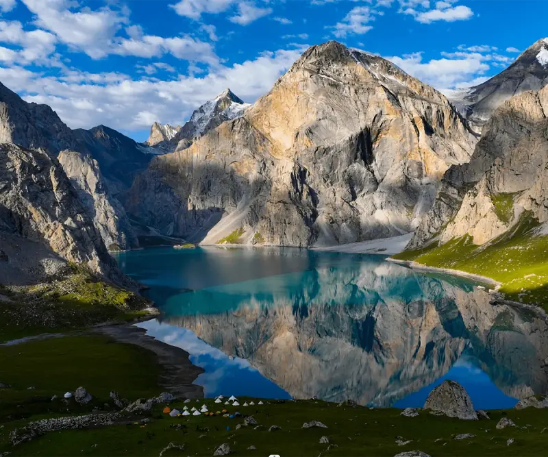 Turquoise alpine lake beneath rugged mountains near Urumqi, Xinjiang