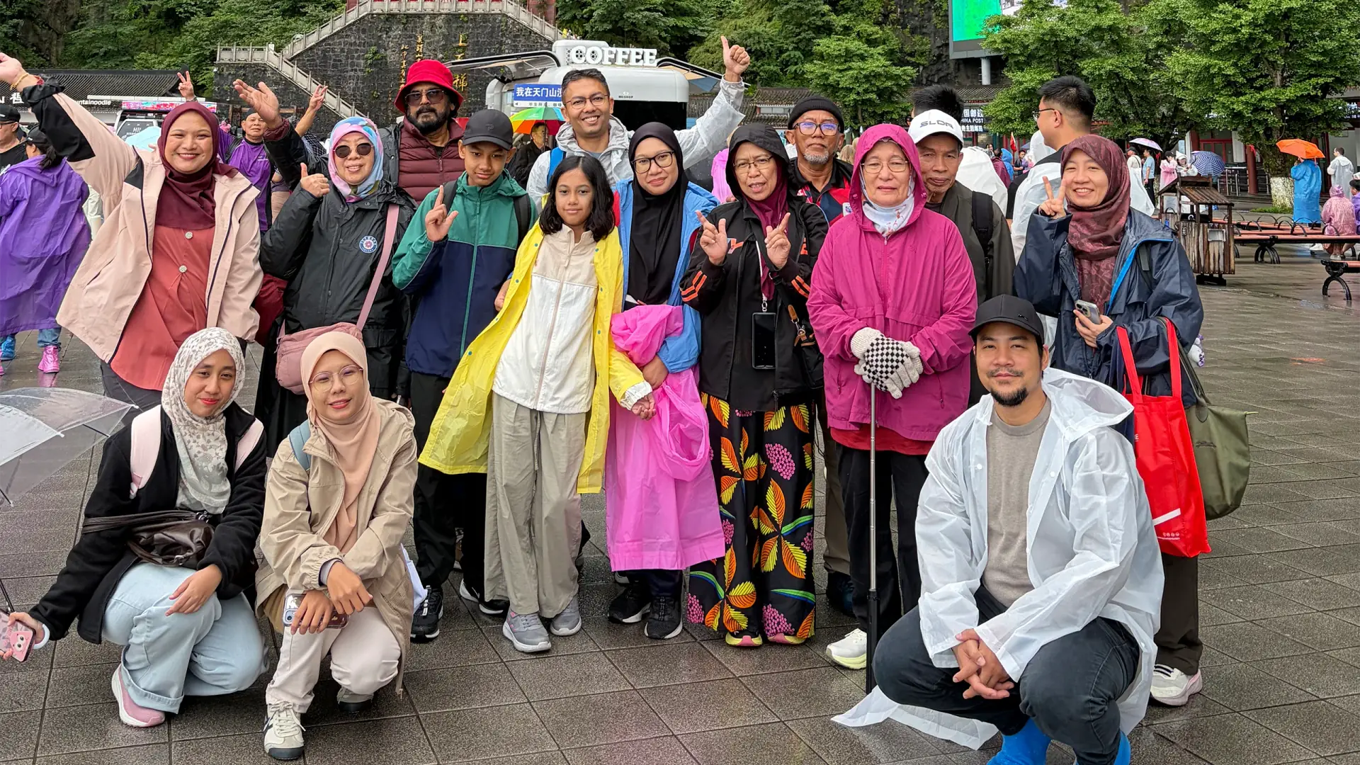 Muslim travel group posing beneath a natural mountain arch in Zhangjiajie