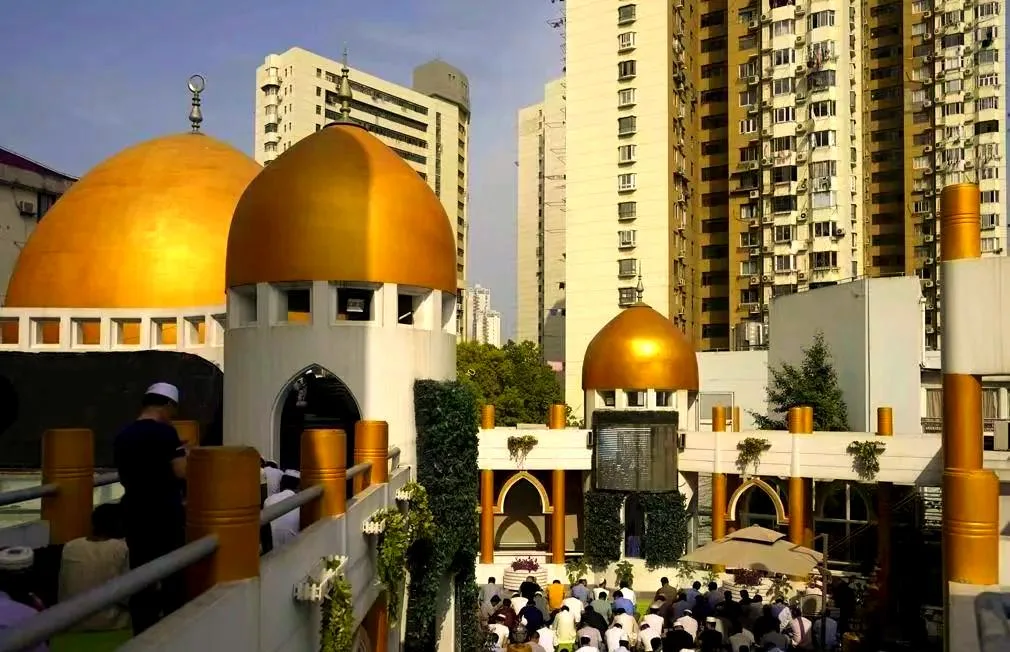 Golden domes of Huxi Mosque with worshippers gathered in the courtyard, Putuo District, Shanghai