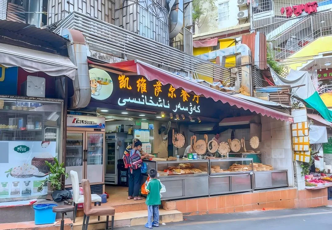 Uyghur halal restaurant with fresh naan and baked goods displayed at the street counter