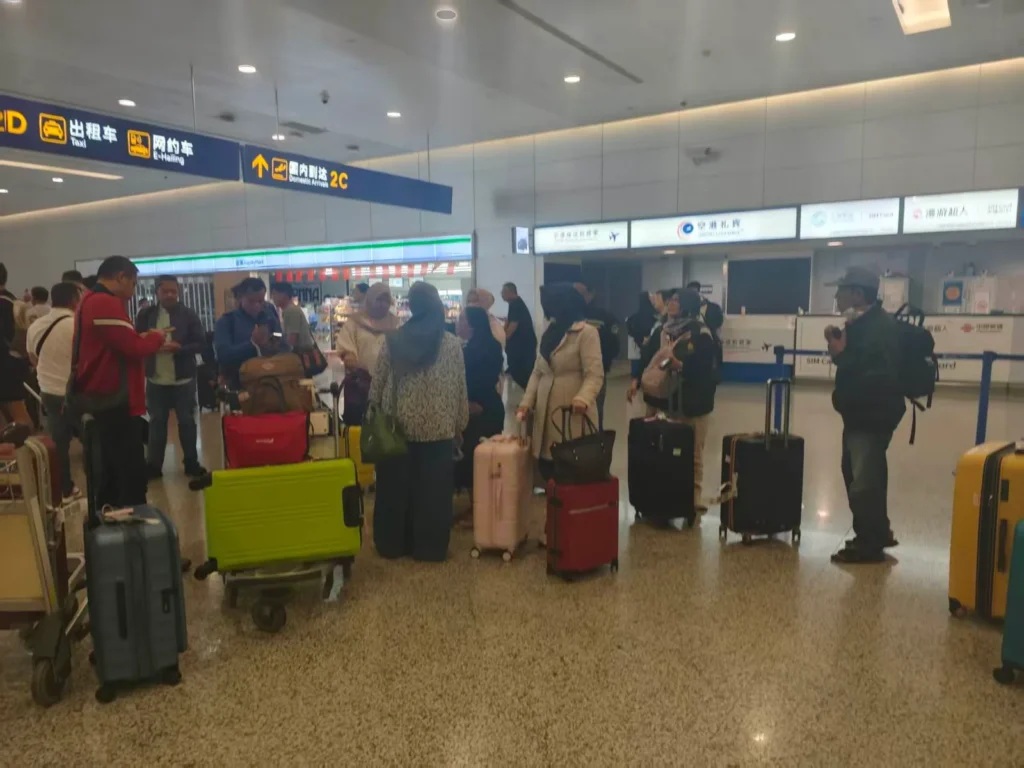 Group of Muslim travelers with luggage meeting at the domestic arrivals hall of a Chinese airport